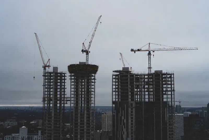 Unfinished condominium towers under construction against the Toronto skyline
