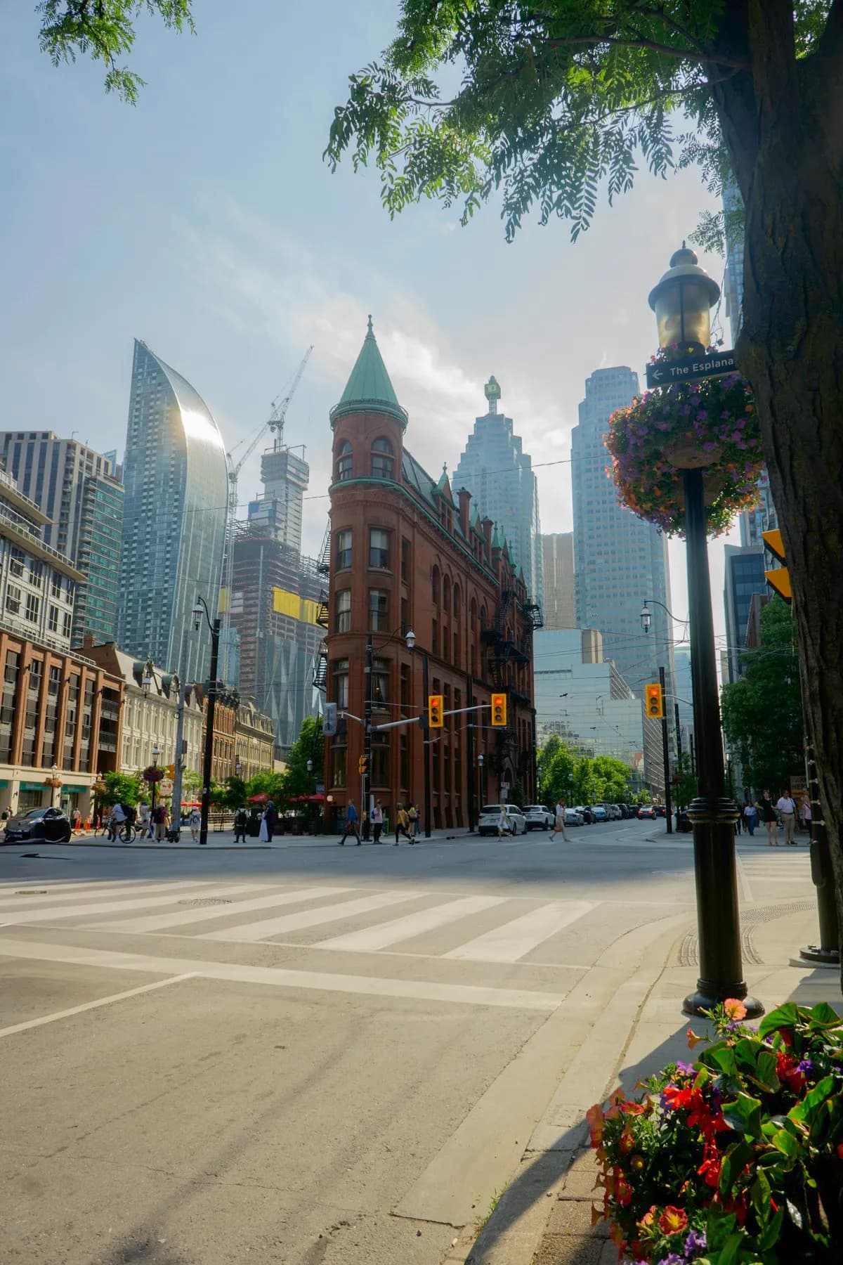 Toronto's historic Gooderham Flatiron Building standing in front of modern glass condo towers — old and new Toronto in one frame
