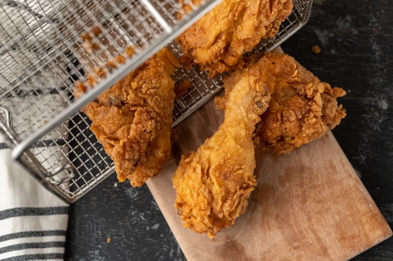 Crispy fried chicken pieces served on a rustic wooden board