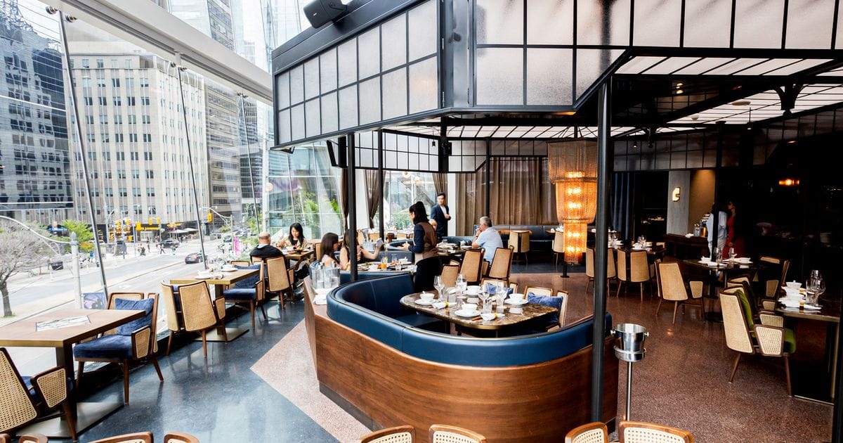 The elegant, multi-level interior of Mott 32 Toronto featuring modern lighting and sophisticated decor.