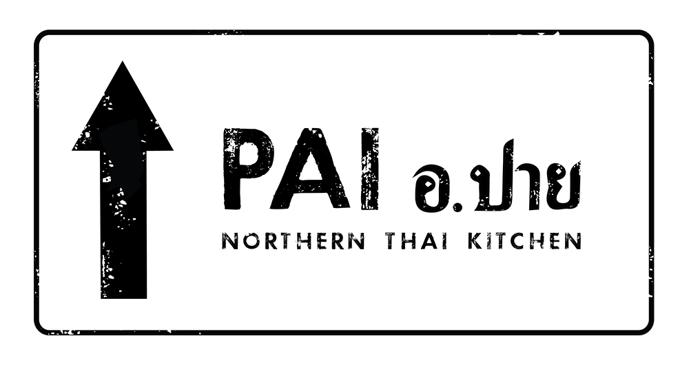 The interior of Pai Northern Thai Kitchen in downtown Toronto, featuring rustic decor, warm lighting, and a lively dining atmosphere.
