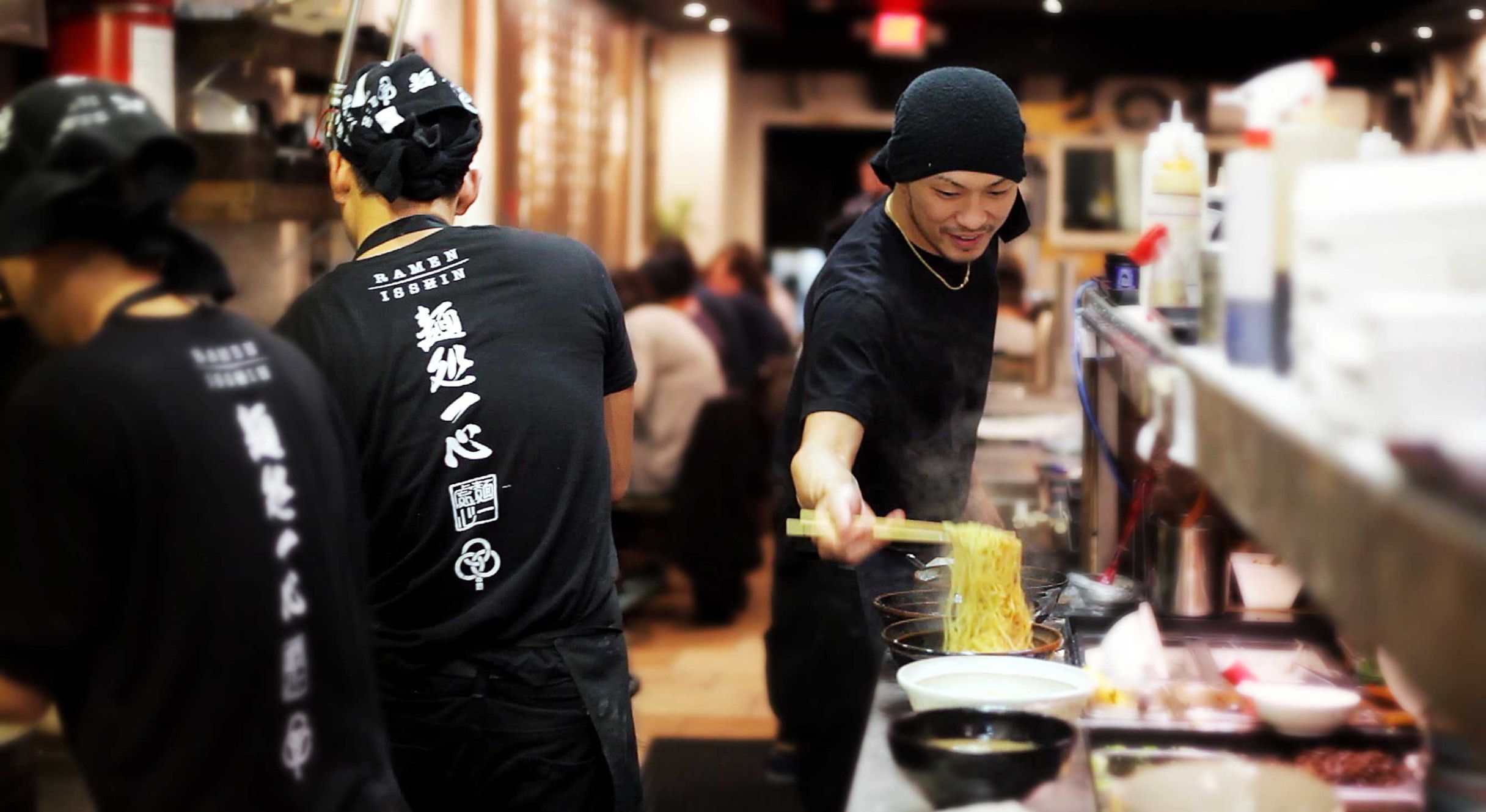 Interior of Ramen Isshin College Street location showing the open kitchen and dining area.