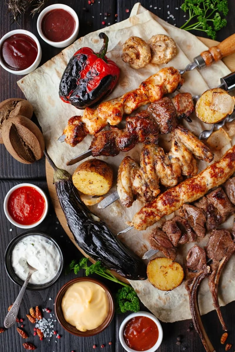 Colourful Caribbean hot sauce bottles and jerk chicken on a rustic counter
