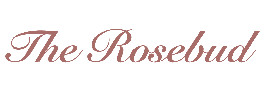 The interior of The Rosebud featuring rose-coloured suede banquettes, walnut panelling, and a marble bar.