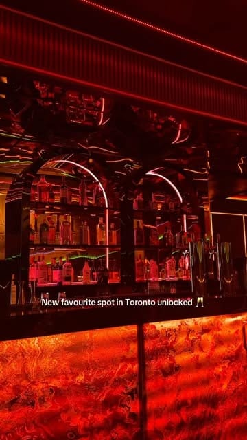 Red neon bar and arched bottle shelves at Trisara in Parkdale